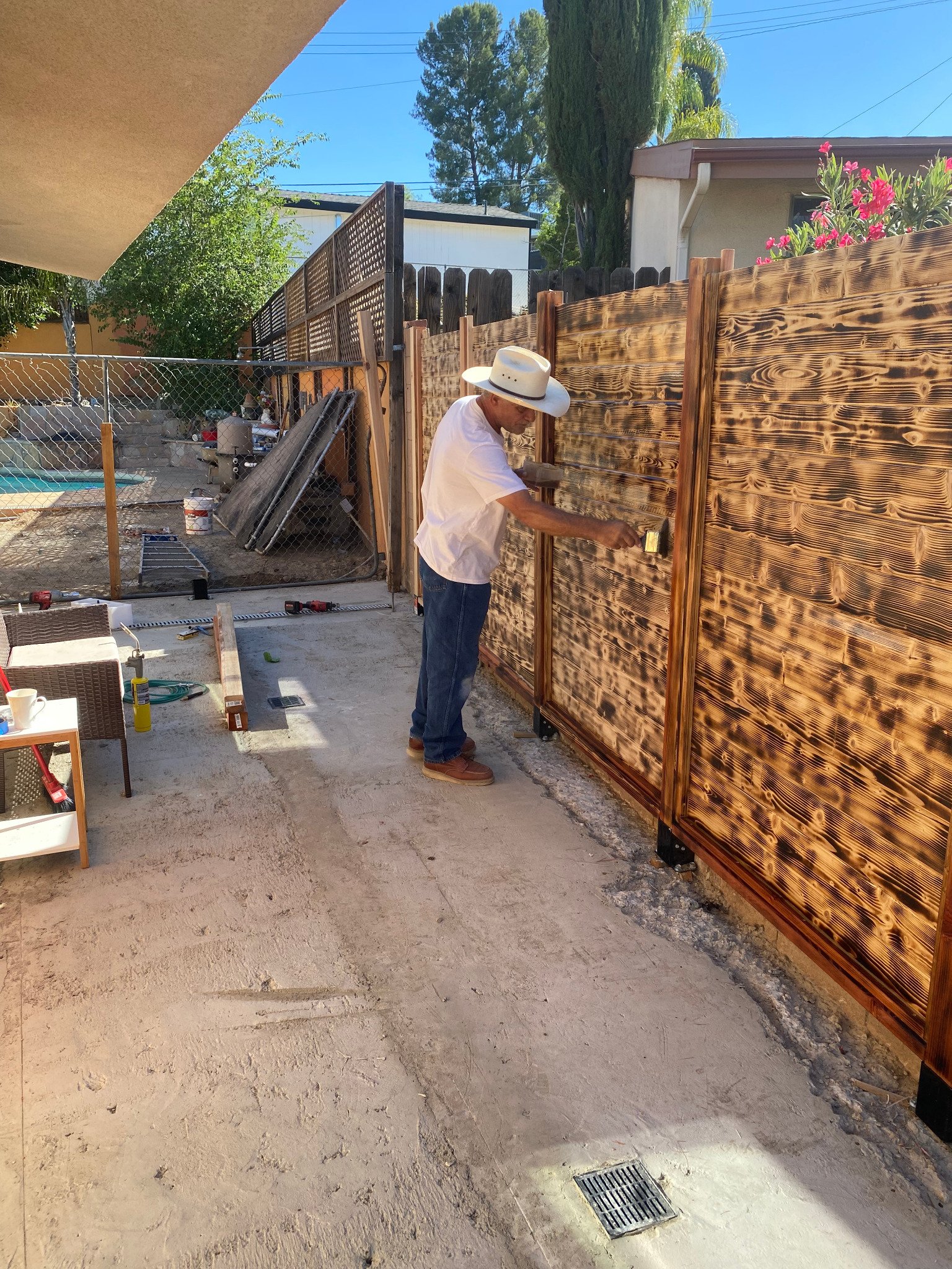 Contractor applying finish to the custom wood fence